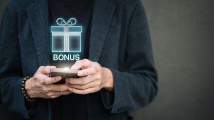 Businessman holding smartphone with virtual hologram bonus gift box.