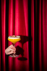 A vibrant yellow Pornstar Martini cocktail in a coupe glass with a fresh passion fruit garnish,...