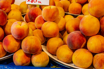 Fresh, large, ripe peaches at the neighborhood market stall.