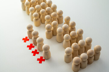 Conceptual representation, with wooden pawns, of corporate layoffs. Concept of layoffs, staff cuts, and mass layoffs.
