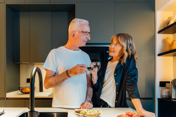 Senior couple sharing a happy morning moment in a modern kitchen, enjoying breakfast and coffee together, symbolizing healthy aging, companionship, and a positive lifestyle
