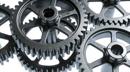 Interlocking metal gears and cogs mechanism isolated on white background, industrial engineering and teamwork concept