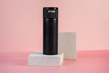 Black cosmetic product or sunscreen cosmetic with stylish props on pink background.