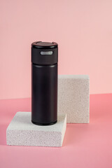 Black cosmetic product or sunscreen cosmetic with stylish props on pink background.