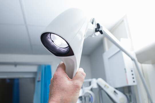Hospital doctor adjusting a modern, bright LED examination lamp for a bedside patient within an accident and emergency room at a typical hospital. - Powered by Adobe