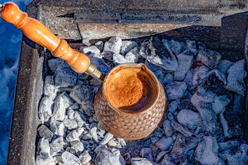 Turkish coffee brewed in a copper pot over a charcoal fire.