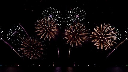 Amazing beautiful colorful firework display over sea on celebration night. Fireworks show for happy new year, 4k footage. - Powered by Adobe