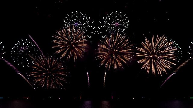 Amazing beautiful colorful firework display over sea on celebration night. Fireworks show for happy new year, 4k footage.	