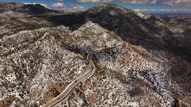 Aerial view of the winding Mount lemmon highway cutting through a mountainous landscape dusted with snow, Tucson, Arizona, United States.