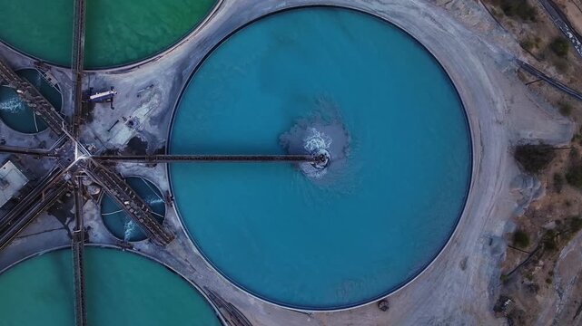 Aerial view of vibrant turquoise and green mining ponds contrasting with the arid landscape, creating a striking visual, Tucson, Arizona, United States.