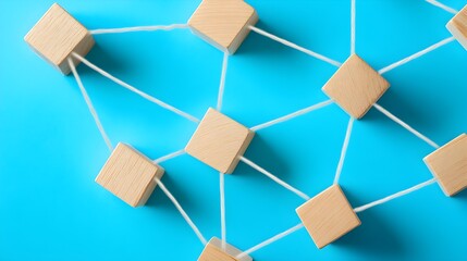 Wooden blocks connected by white strings on blue background