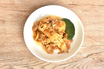 spicy fried slice pickled bamboo shoot with beef meat in curry sauce on plate