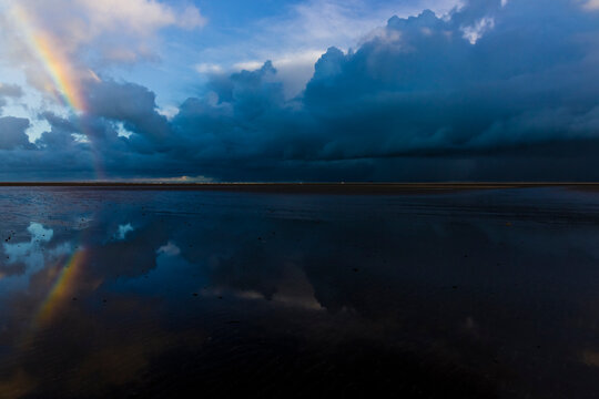 Red Wharf Bay beachscape, seascape and cloudscape reflection scene featuring a rainbow, Area of Outstanding Natural Beauty, Anglesey, Gwynedd