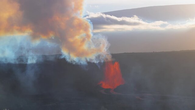 Aerial view of the fiery Kilauea volcano erupting with orange lava and smoke contrasting against the dark landscape, Kilauea, Hawaii, United States.