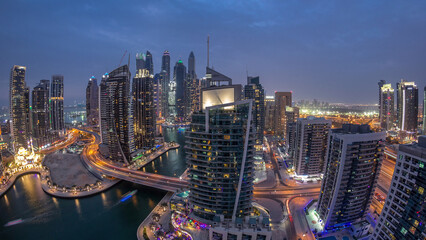 Aerial view of Dubai Marina residential and office skyscrapers with waterfront day to night timelapse