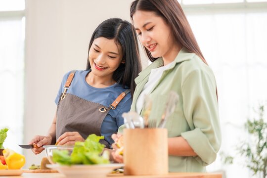 Friends prepare healthy food in a kitchen during daytime - Powered by Adobe