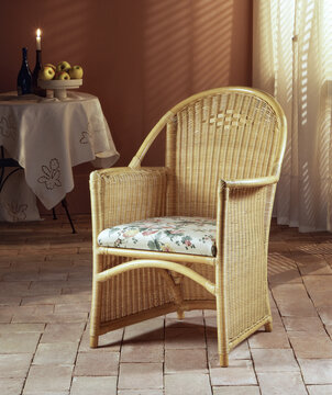Still life of a wicker chair on a stone floor