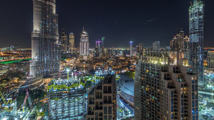 Panoramic skyline view of Dubai downtown after sunset with mall, fountains and skyscrapers aerial day to night timelapse