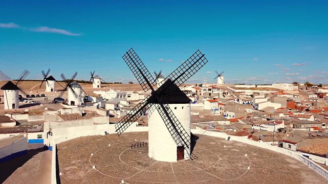 erial drone shot in Campo de Criptana, Castilla-La Mancha, Spain . Pulling back from a traditional windmill to reveal the historic village and iconic Manchegan landscape. High quality 4k footage