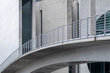 Curved concrete pathway within modern architecture showing geometric urban forms, outdoors minimalism, structure, design and perspective in a smooth visual composition