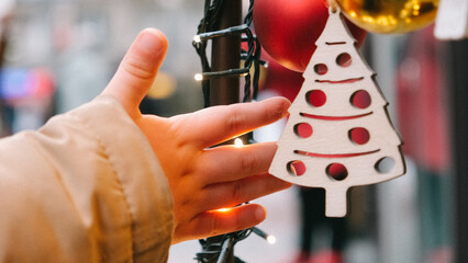 A child's hand with Christmas tree decorations. Childhood at Christmas.