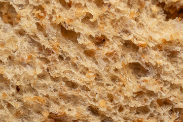 Close up of a piece of whole grain bread with visual fibers and grains. Dutch airy baked bread.