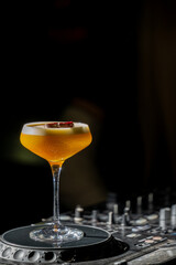 A vibrant Pornstar Martini cocktail is presented in a sleek coupe glass on a bar counter, with a halved passion fruit garnish and moody, dark background