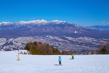 冬の長野県富士見町の富士見パノラマリゾートのゴンドラ山頂駅付近から八ヶ岳連峰のパノラマ風景とスキーヤー等を見る