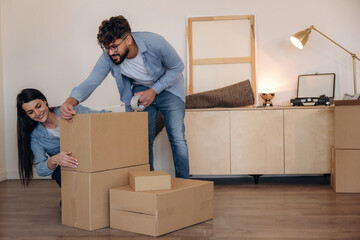 Using scotch as glue. Couple packing cardboard boxes while preparing to move into a new home