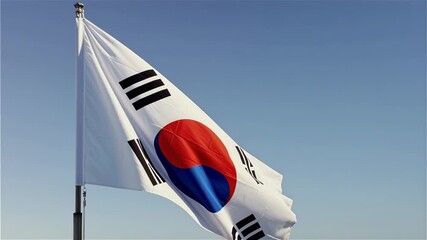 South Korean flag waving proudly in wind against clear blue sky showing national symbol and patriotic spirit