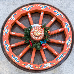 Vibrant folk art wagon wheel with christmas wreath and snow