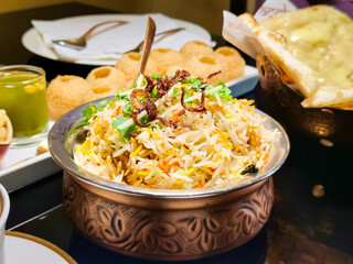 Close-up biryani rice in an ornate brass pot at an Indian restaurant. Delicious traditional Indian food.