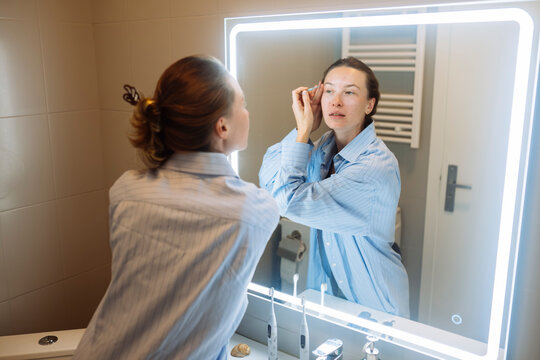 Casually dressed woman enhances her look with careful makeup tweaks - Powered by Adobe