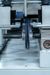 Vertical view of industrial machine rollers and metal shaft in production line