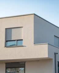 Modern residential building with sleek design features under clear blue sky during late afternoon