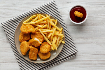 Chicken Nuggets with French Fries on a Plate, top view.