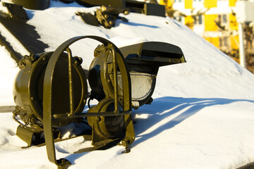 Headlight on a Dark Military or Heavy Vehicle Surrounded by Snow