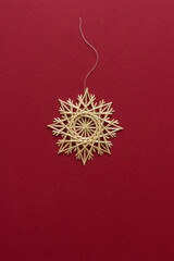 Straw snowflake. Snowflake are made of straw on a red background. Christmas decor. Top view. Straw weaving. Lutsk, Ukraine