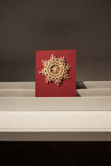 The straw star is illuminated by the sun. Snowflakes are made of straw on a red background. Straw snowflakes. Straw weaving. Lutsk, Ukraine