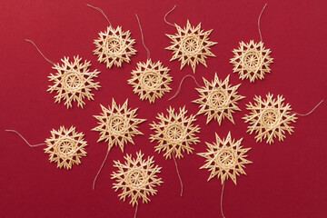 Straw snowflakes. Snowflakes are made of straw on a red background. Christmas decor. Top view. Straw weaving. Lutsk, Ukraine