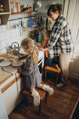 Mother and children washing dishes in kitchen