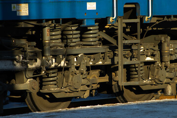 Wheels and Complex Coil Spring Suspension on a Blue Railway Freight Car Bogie