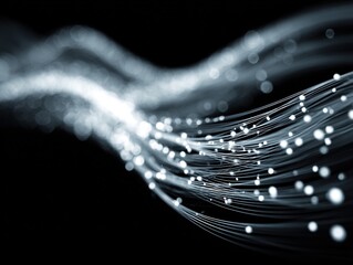 Flowing strands of luminous white fiber-like lines carrying glowing particles through darkness, creating a sleek futuristic visual of motion, data, and connectivity