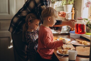 Children preparing breakfast with parent at home