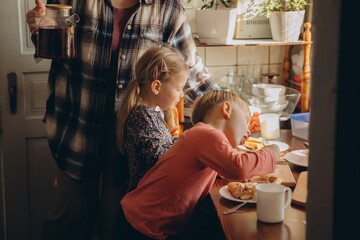 Parent serving breakfast to children at home