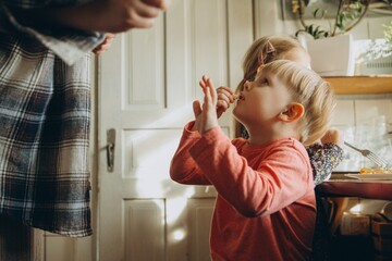 Toddler boy eating snack at home kitchen