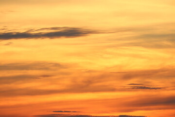 Fototapeta premium Golden sunset sky: Witness the breathtaking grandeur of a golden sunset sky, ablaze with hues of orange, yellow, and a touch of purple. Clouds dance across the canvas.