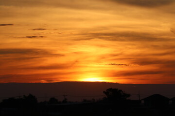 Golden Hour Spectacle: Witness the sky ablaze with the fiery hues of sunset, as the sun dips below the horizon, painting the clouds in vibrant shades of orange and gold.