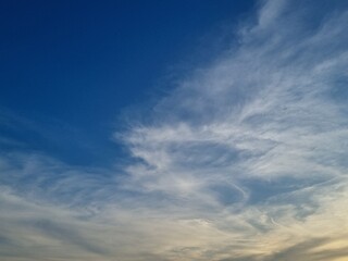 Celestial Symphony: A vast expanse of cerulean canvas adorned with ethereal, wispy clouds, a dance of light and shadow, invites contemplation and wonder.