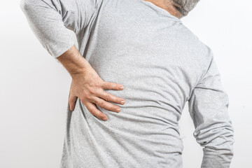 The older man grabbed his lower back. Radiculitis symptom, inflammation, pain in the spine of the senior man.